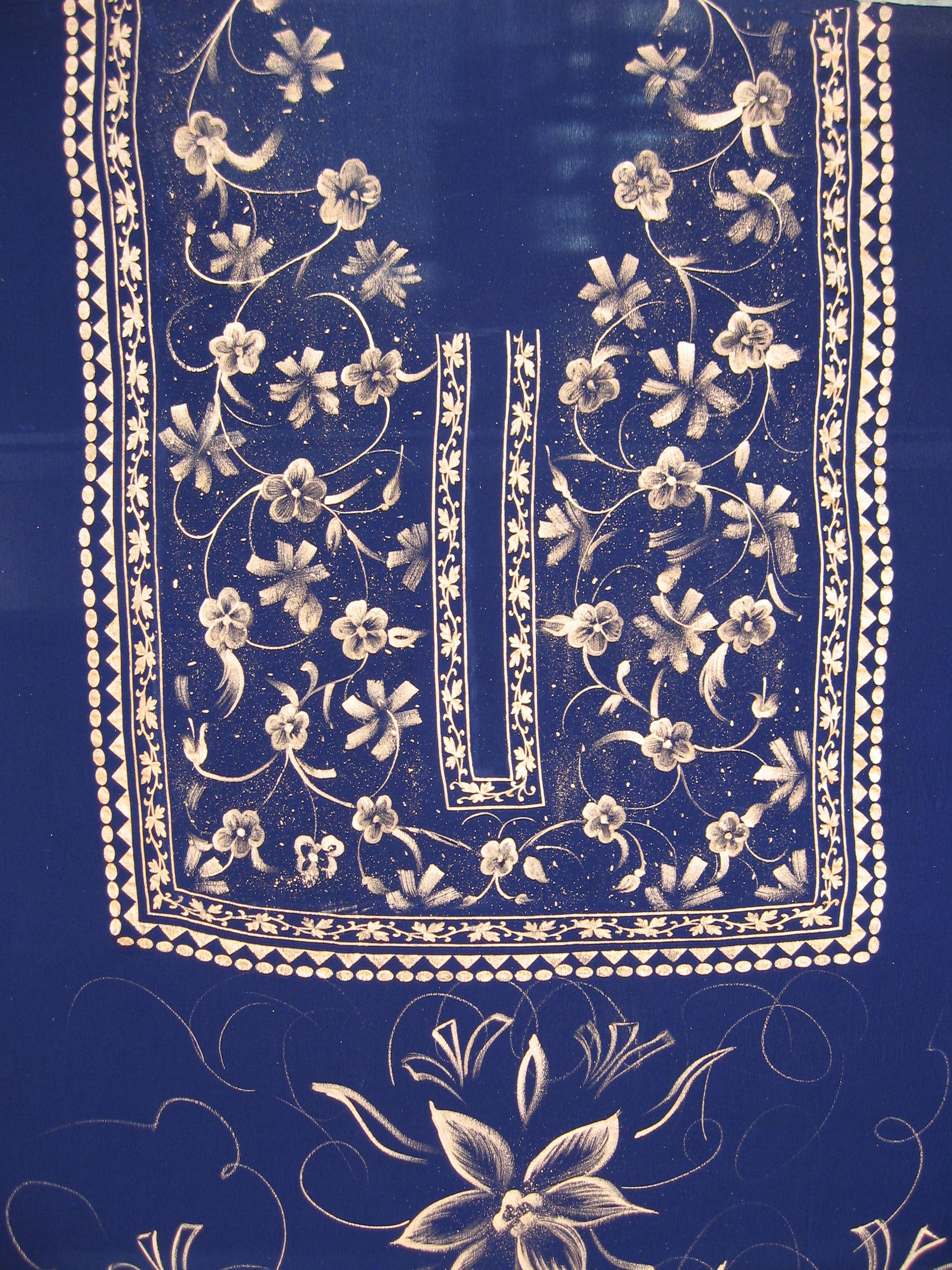 Detailed gold and white floral painting on blue fabric