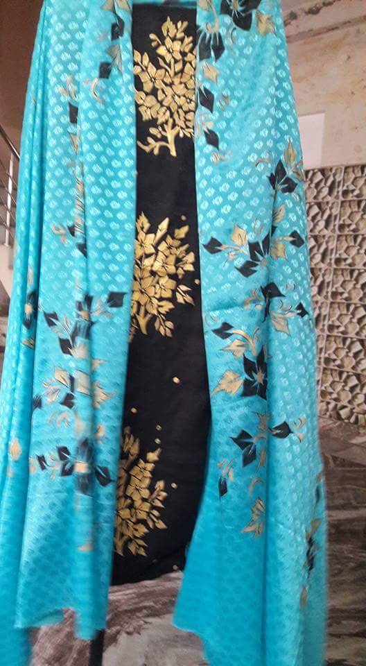 Turquoise fabric decorated with black and gold hand-painted flowers