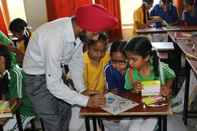 Art teacher helping children during a drawing class